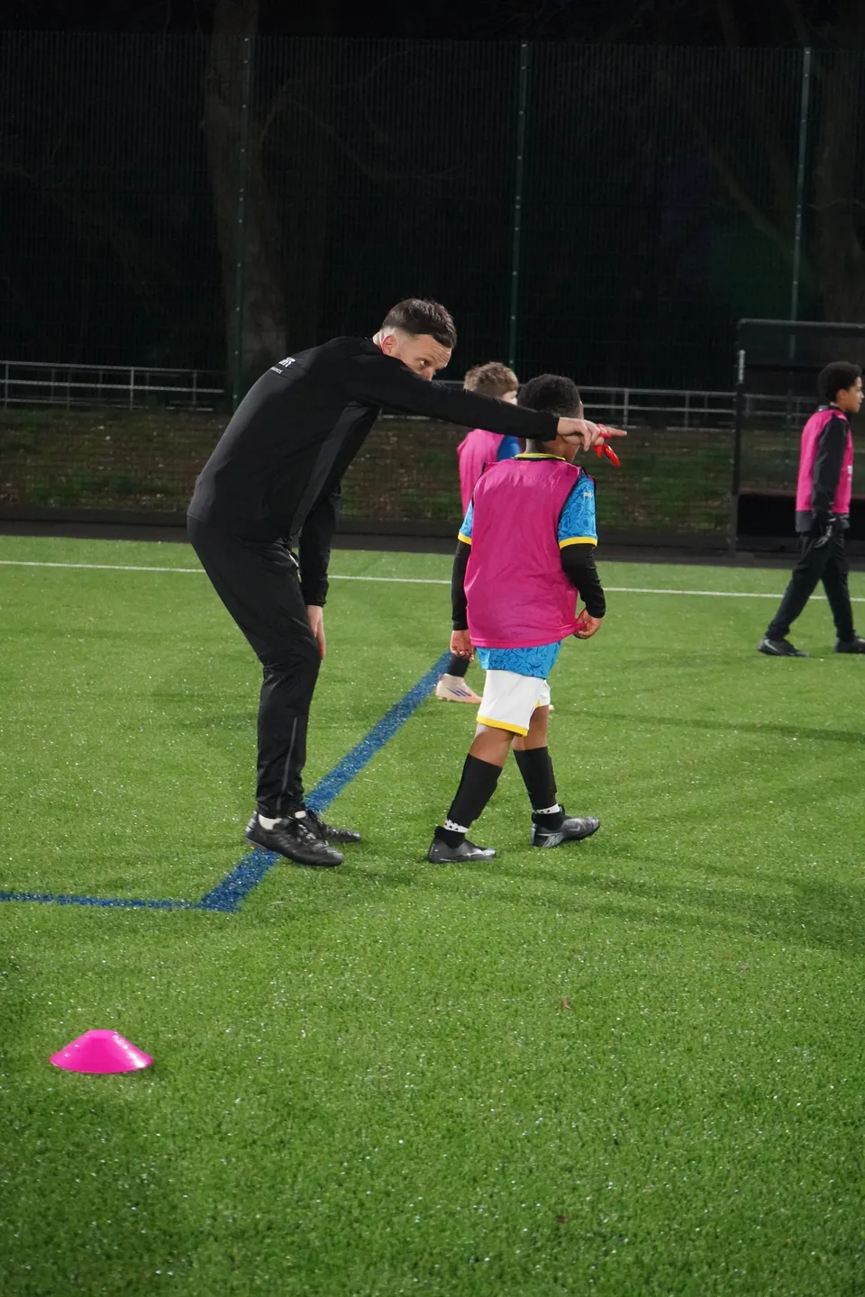 A Touchtight coach helping a young player at training