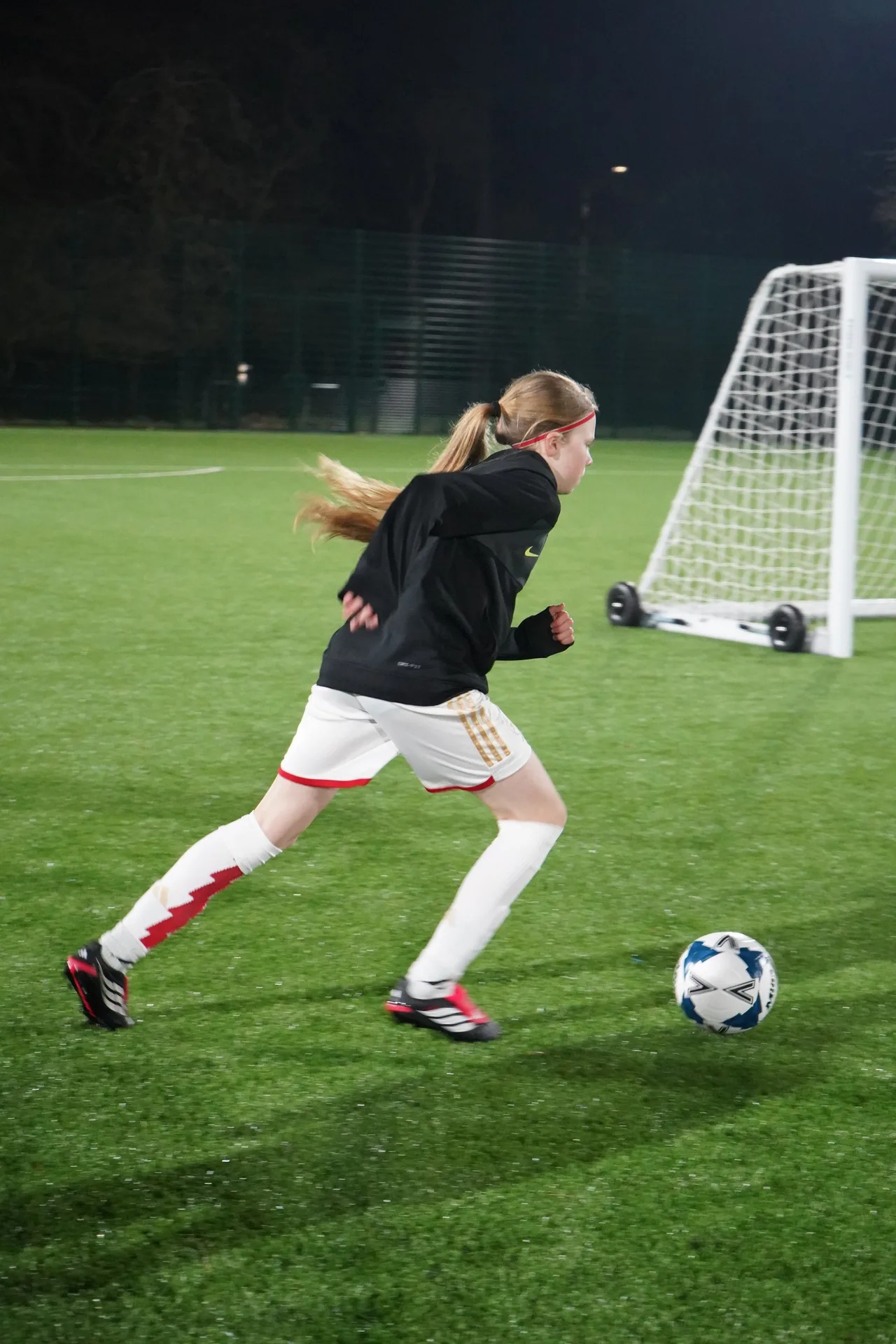 A player attacking the goal at a floodlit Touchtight training session